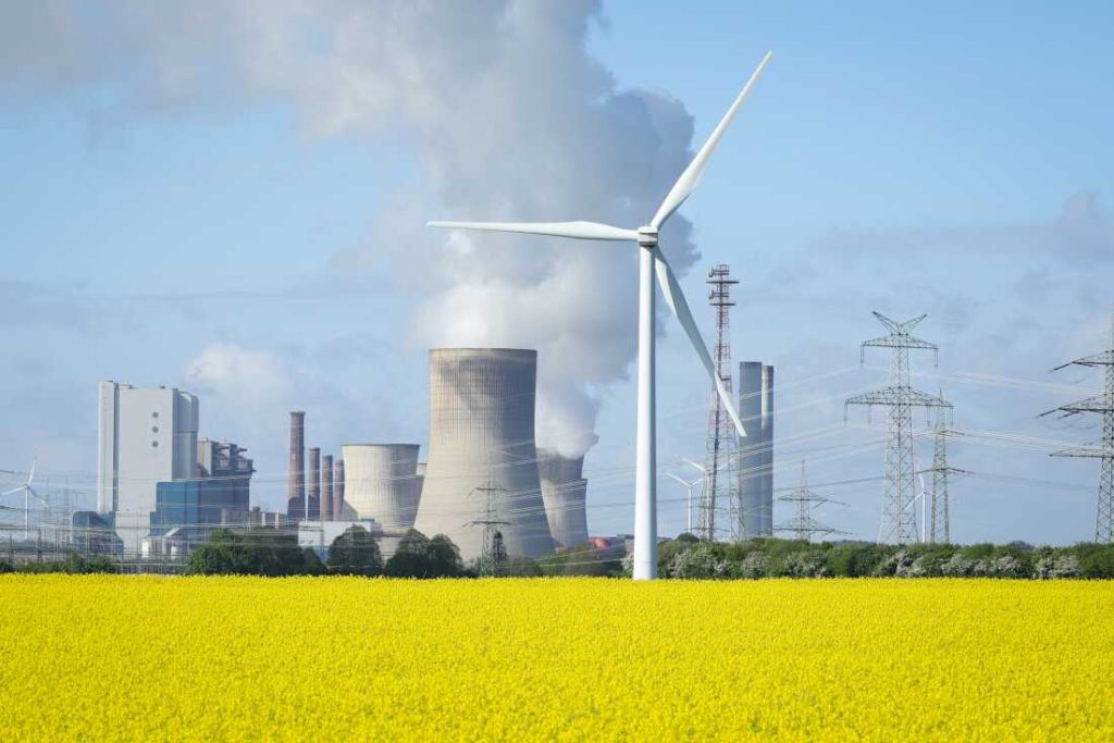 wind turbines stand next to a yellow blossoming rape field wind turbines stand next to a yellow blossoming rape field